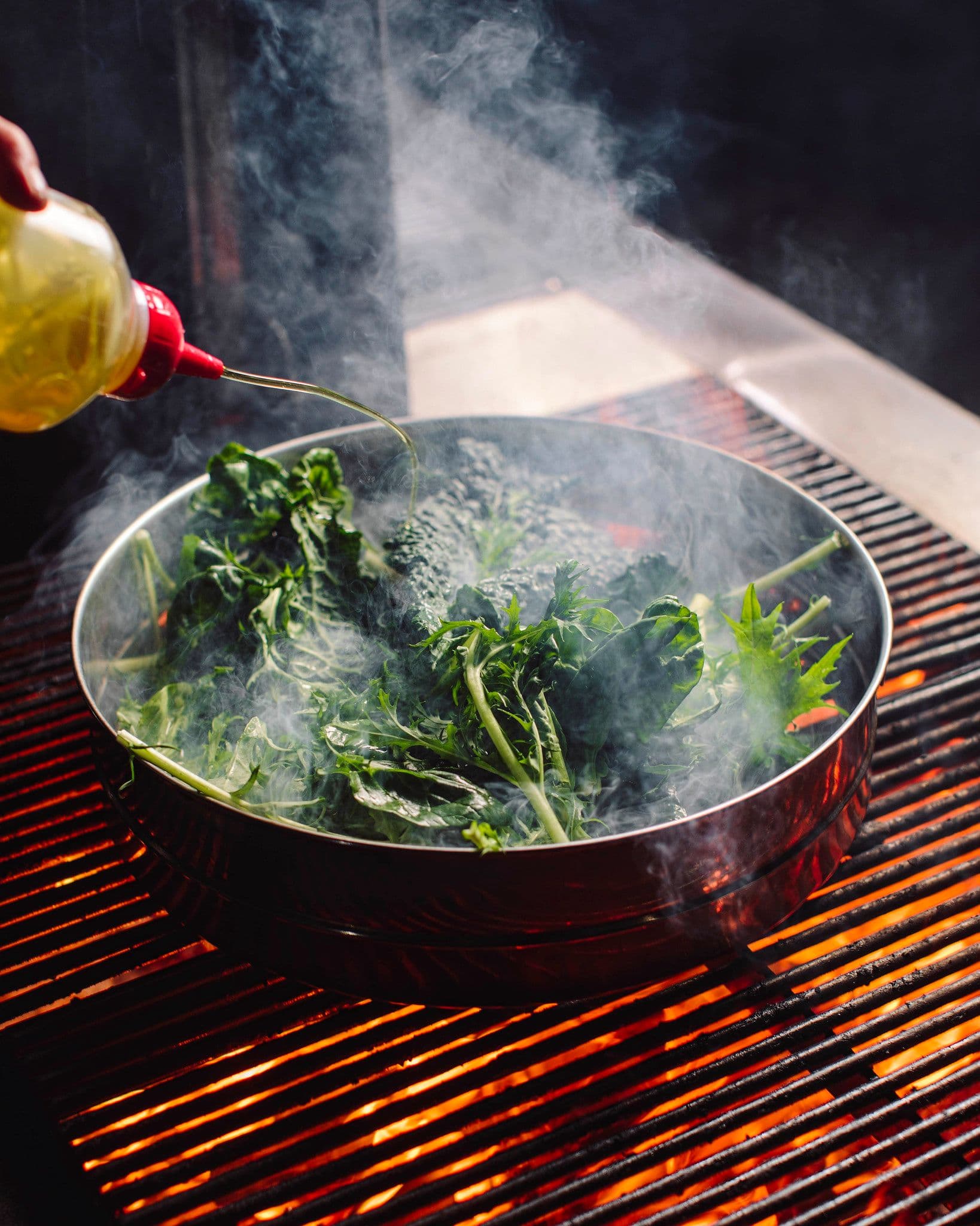 Delicious leafy greens cooked in a oiled pan over a fire