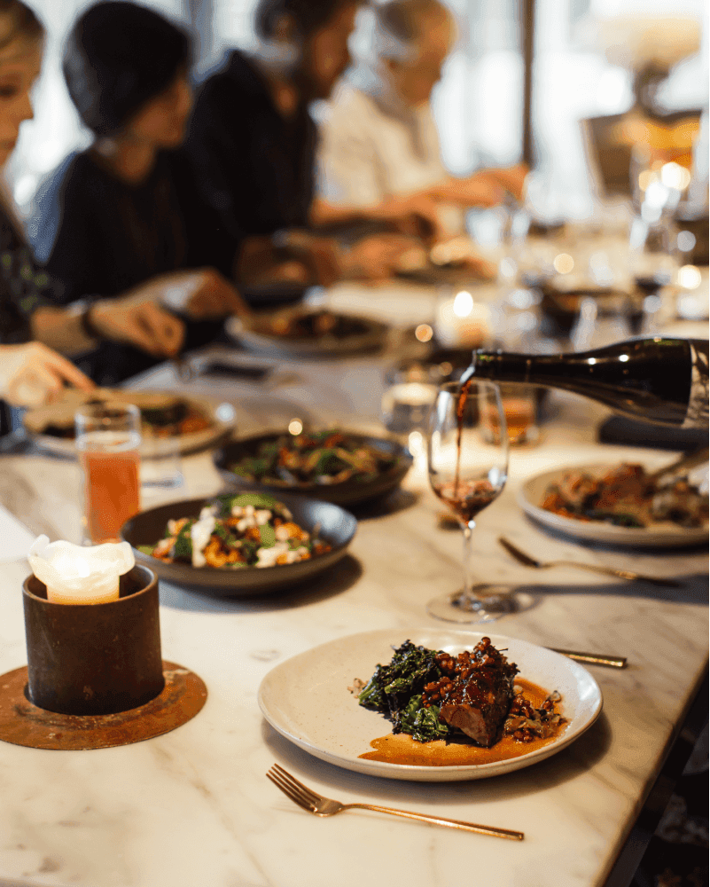 A marble table with a range of delicious meals and wine being poured